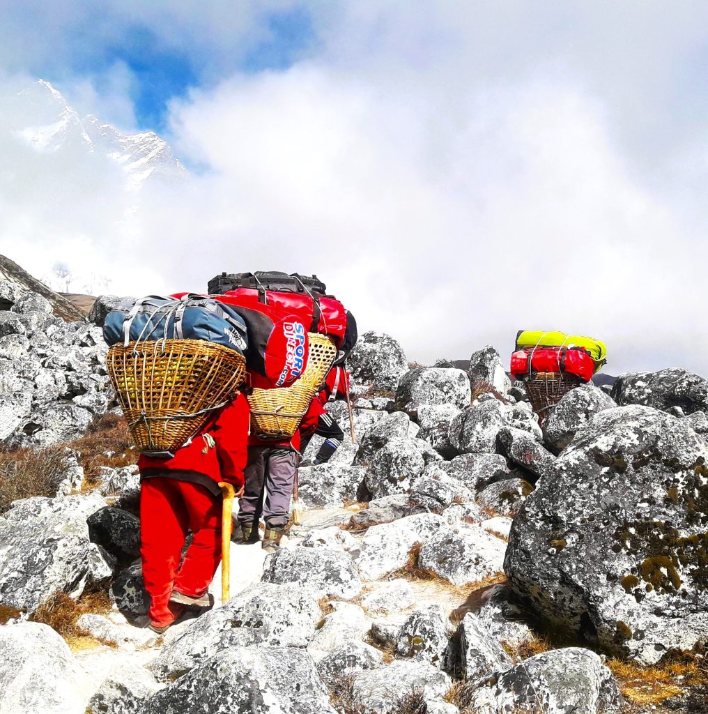 Porters carrying their loads in the Everest region; working as a porter with The Monkey Travels.