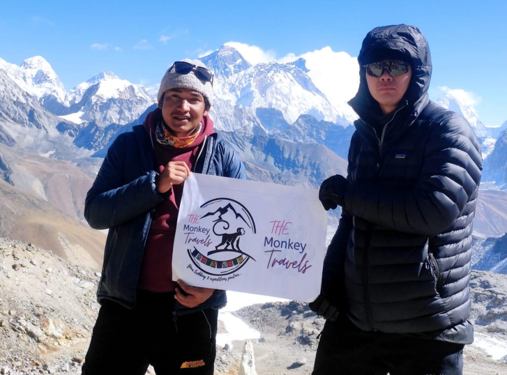 two men holding the monkey travels banner in the three pass trekking route.